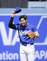 　キャッチボール中、投げたボールがスタンドに入り、帽子を取る大谷（共同）