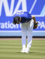 　キャッチボール中、投げたボールがスタンドに入り、頭を下げる大谷（共同）