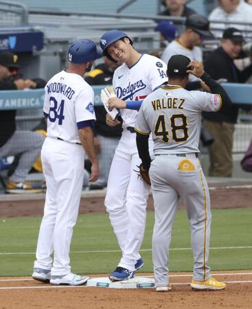 　１回、四球で出塁し一塁コーチとヘルメットを合わせる大谷（共同）