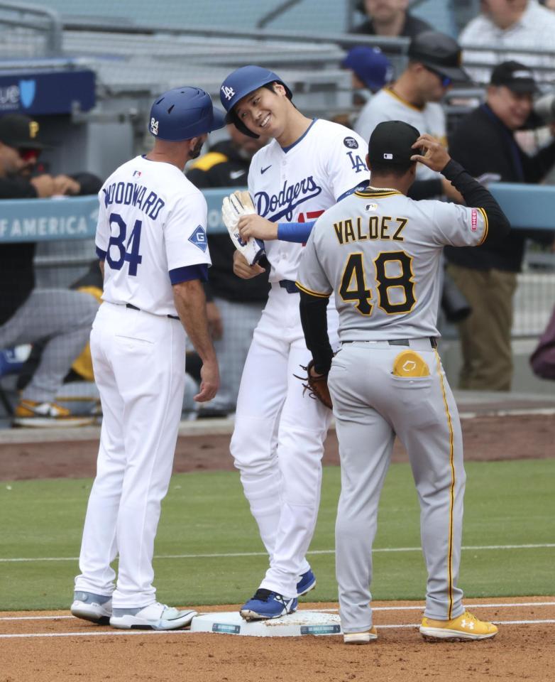 　１回、四球で出塁し一塁コーチとヘルメットを合わせる大谷（共同）