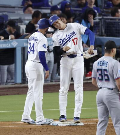 　４回、四球で出塁し一塁コーチとヘルメットを合わせる大谷（共同）