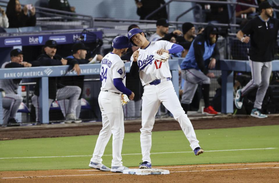 　３回、四球で出塁し一塁コーチとヘルメットを合わせる大谷（共同）