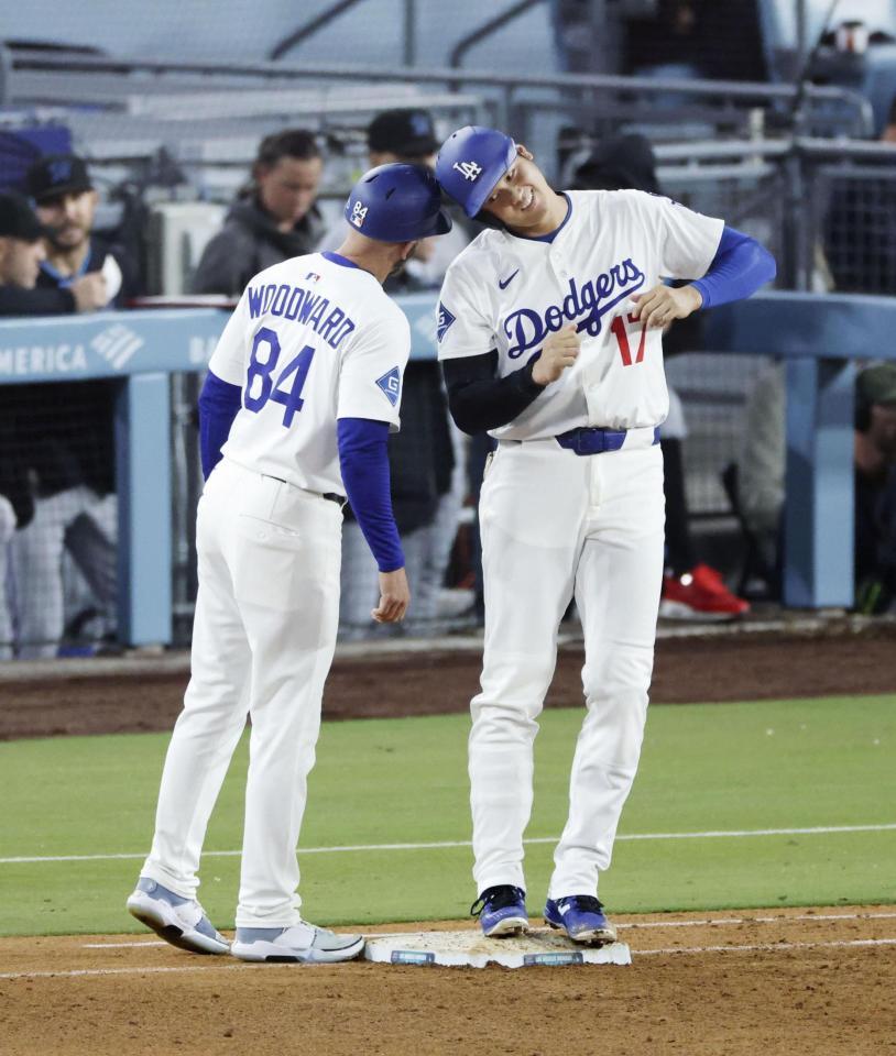 　６回、四球で出塁し一塁コーチとヘルメットを合わせる大谷（共同）