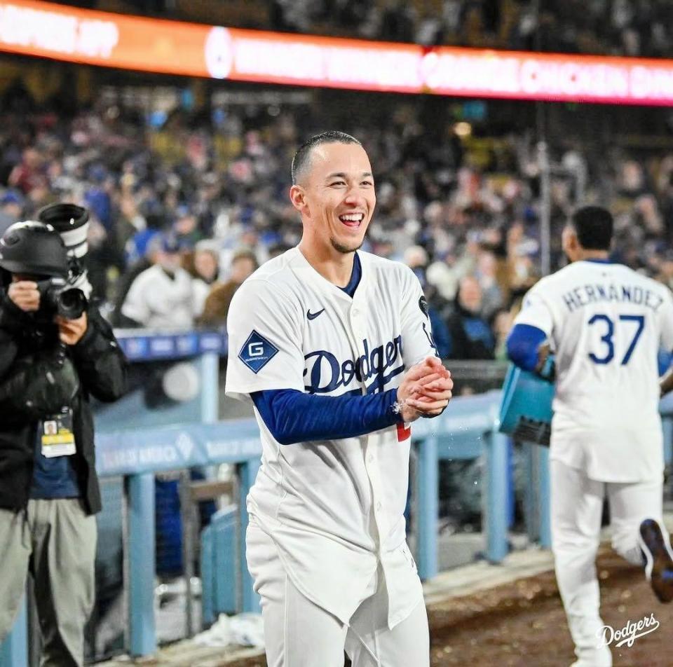 　バケツシャワーを浴びせさっそうと退散するＴ・ヘルナンデス。リポーターを見て笑顔のエドマン（ロサンゼルス・ドジャース提供）