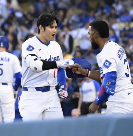 　マーリンズ戦の１回、先頭打者本塁打を放ちＴ・ヘルナンデス（右）とタッチを交わすドジャース・大谷＝ロサンゼルス（共同）
