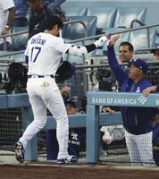 　マーリンズ戦の１回、先頭打者本塁打を放ち、ロバーツ監督（右）に迎えられるドジャース・大谷＝ロサンゼルス（共同）