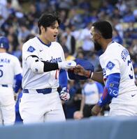 　マーリンズ戦の１回、先頭打者本塁打を放ちＴ・ヘルナンデス（右）とタッチを交わすドジャース・大谷＝ロサンゼルス（共同）