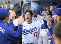 　マーリンズ戦の１回、７号となる先頭打者本塁打を放ち、ベンチで迎えられるドジャース・大谷＝ロサンゼルス（共同）