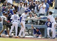 　マーリンズ戦の６回、２ランを放ち大谷（右端）からヒマワリの種で迎えられるドジャースのフリーマン＝ロサンゼルス（共同）