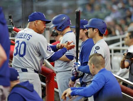 　ブレーブス戦のベンチでロバーツ監督（左）から声をかけられるドジャース・大谷（共同）