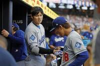 　ブレーブス戦の３回を終えた山本（右）に声をかけるドジャース・大谷（共同）