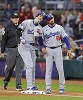 　ブレーブス戦の１回、中前打を放ち一塁コーチ（右）とヘルメットを合わせるドジャース・大谷（共同）