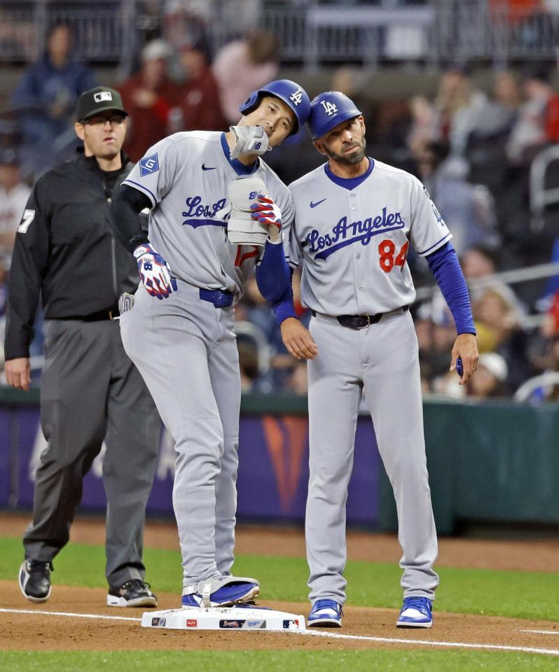 　ブレーブス戦の１回、中前打を放ち一塁コーチ（右）とヘルメットを合わせるドジャース・大谷（共同）