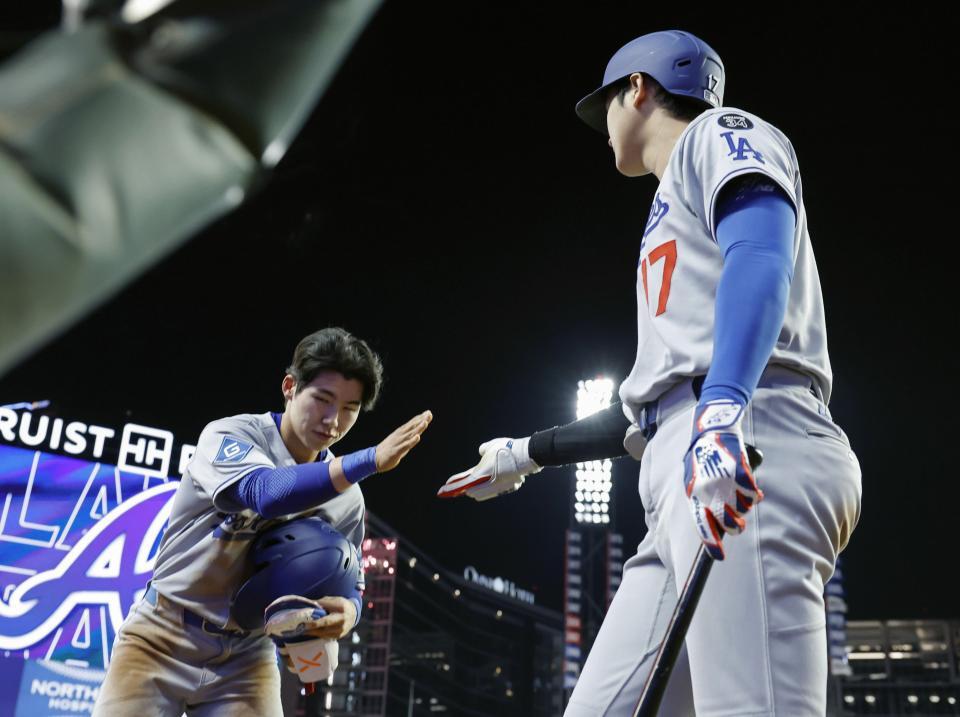 　ブレーブスに敗れ、代走で出場したキム・ヘソン（左）とタッチを交わすドジャース・大谷（提供・共同通信社）