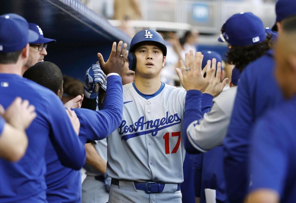 　６回、フリーマンの適時打で生還し、ナインとタッチを交わす大谷（共同）