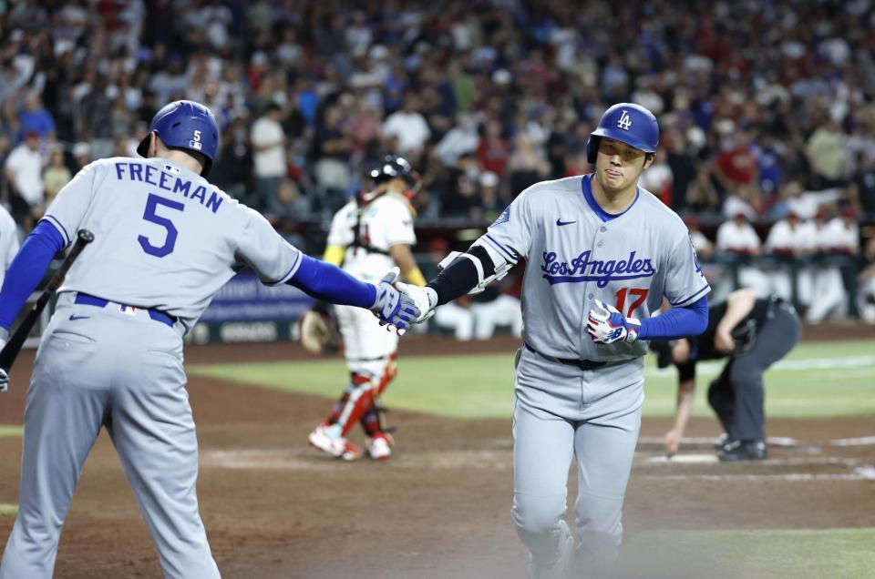 　ダイヤモンドバックス戦の９回、１１号ソロを放ちフリーマン（５）に迎えられるドジャース・大谷（共同）