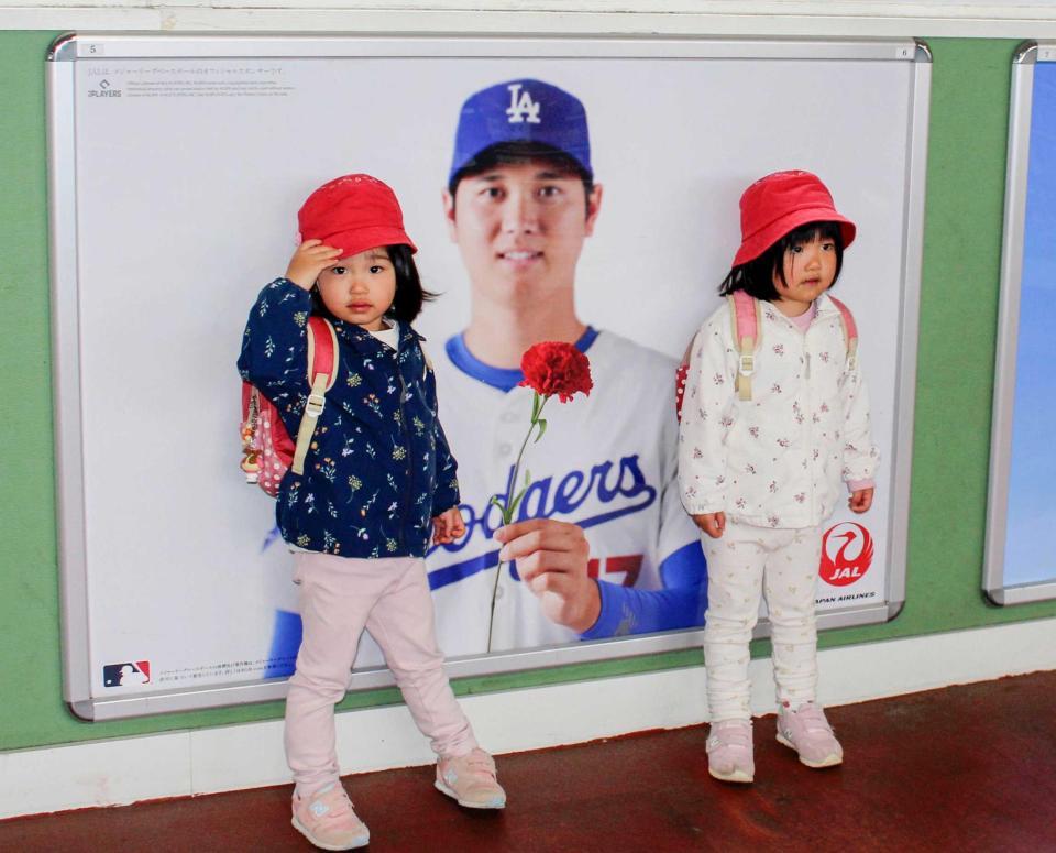 　ＪＲ花巻駅に掲出された日本航空の限定広告と記念撮影する子どもたち
