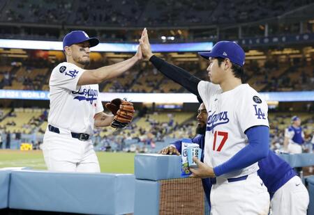 　９回に登板したロハス（左）とタッチする大谷（共同）