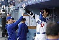 　アスレチックス戦のベンチでポーズをとり合う大谷（右）と山本（共同）