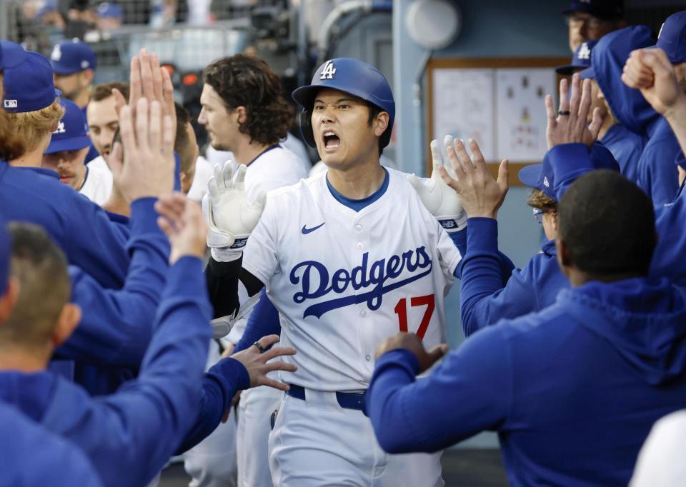 　アスレチックス戦の１回、先頭打者本塁打を放ちチームメートとタッチを交わすドジャース・大谷（共同）