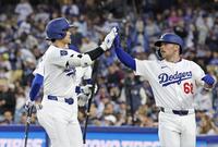 　２回、犠飛を放ち、生還した三走ラッシング（右）とタッチを交わす大谷（共同）