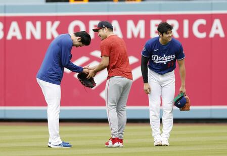 　試合前、あいさつを交わすドジャース・佐々木（左）とエンゼルス・菊池。右はドジャース・大谷（共同）