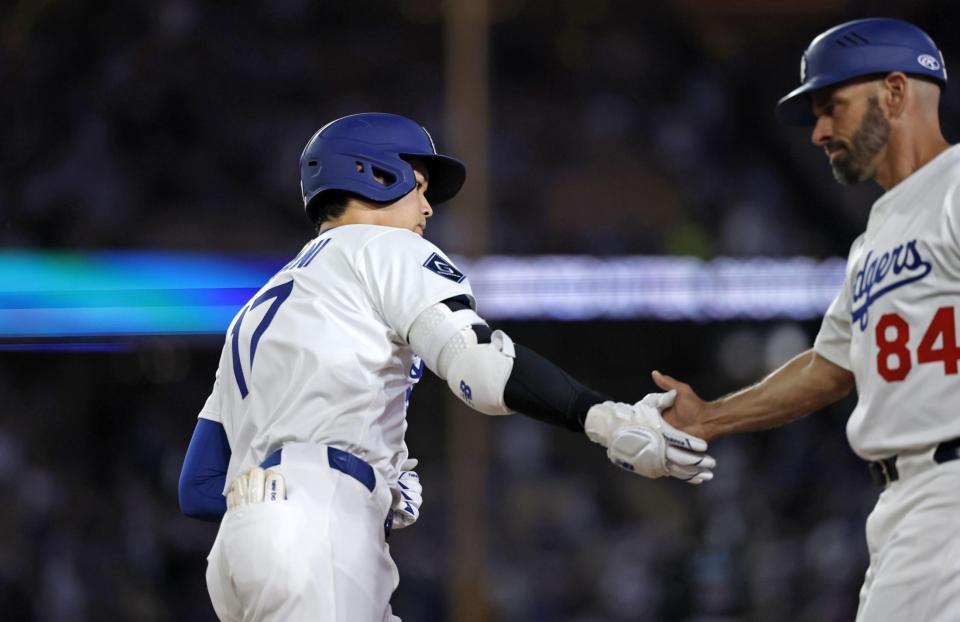 　６回、１７号ソロを放ち、タッチを交わす大谷（共同）