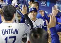 　先発し、７回を無失点で投げ終えチームメートとタッチを交わす山本（共同）