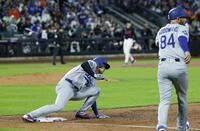 　３回、ベッツの飛球で一塁からタッチアップする際に足を滑らせる大谷（左）＝共同