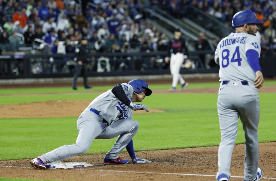 　３回、ベッツの飛球で一塁からタッチアップする際に足を滑らせる大谷（左）＝共同