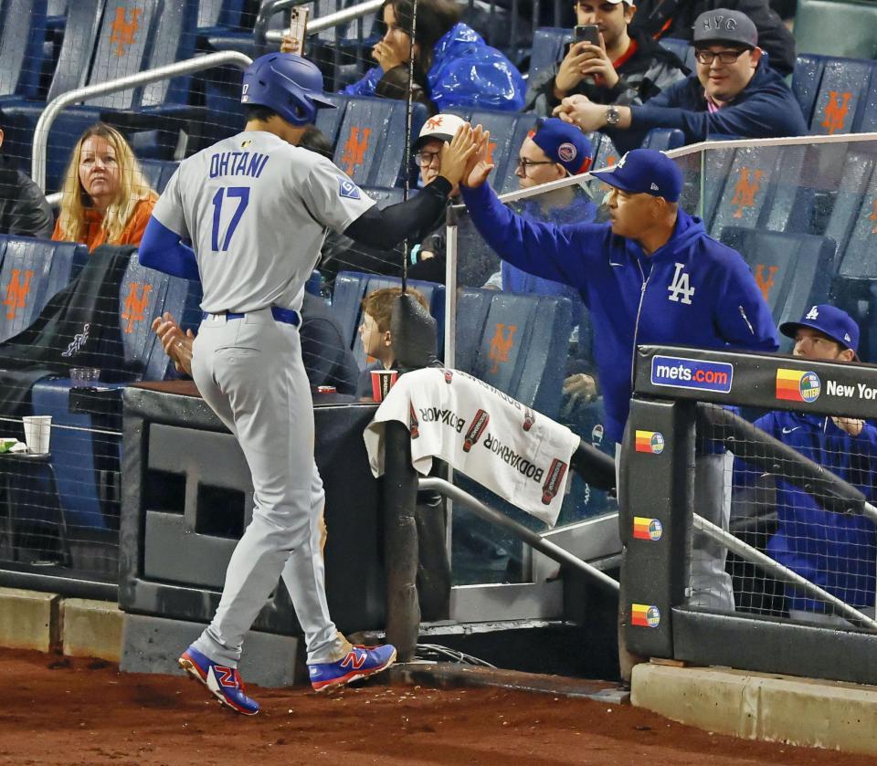 　３回、後続の２点打で生還し、ロバーツ監督（右）とタッチを交わす大谷（共同）