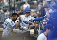 　メッツ戦の１回、先頭打者本塁打を放ち、迎えられるドジャース・大谷（左から２人目）＝共同