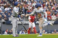 　７回、相手投手の暴投で生還したＫ・ヘルナンデス（右）を迎えるドジャース・大谷（共同）