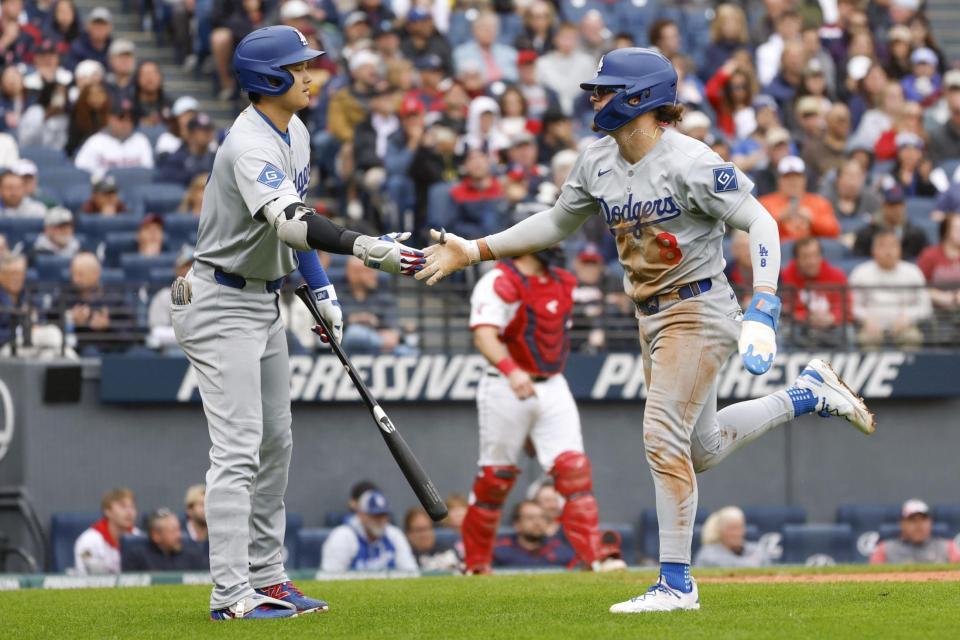 　７回、相手投手の暴投で生還したＫ・ヘルナンデス（右）を迎えるドジャース・大谷（共同）