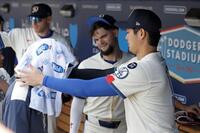 　試合前のベンチで佐々木（左）にタオルをかぶせる大谷（共同）