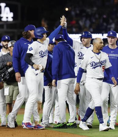　勝利し、サヨナラ打のフリーマン（右から３人目）とタッチを交わす大谷（共同）