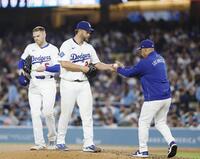 　５回途中、ロバーツ監督（右）にボールを渡し、降板するカーショー（共同）