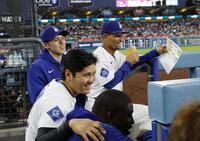 　ベンチで笑顔を見せる大谷や佐々木（左端）ら（共同）