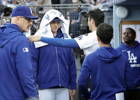 　試合前のベンチで、大谷にタオルを掛けられるドジャース・佐々木（共同）