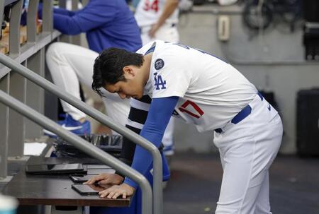 　メッツ戦のベンチでタブレット端末を見るドジャース・大谷（共同）