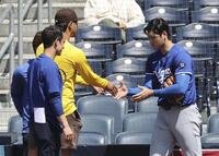 　実戦形式に登板後、ダルビッシュとあいさつを交わす大谷（右）＝共同