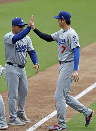 　パドレスに勝利し、ロバーツ監督（左）とタッチを交わす大谷（共同）