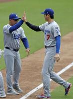 　パドレスに勝利し、ロバーツ監督（左）とタッチを交わす大谷（共同）