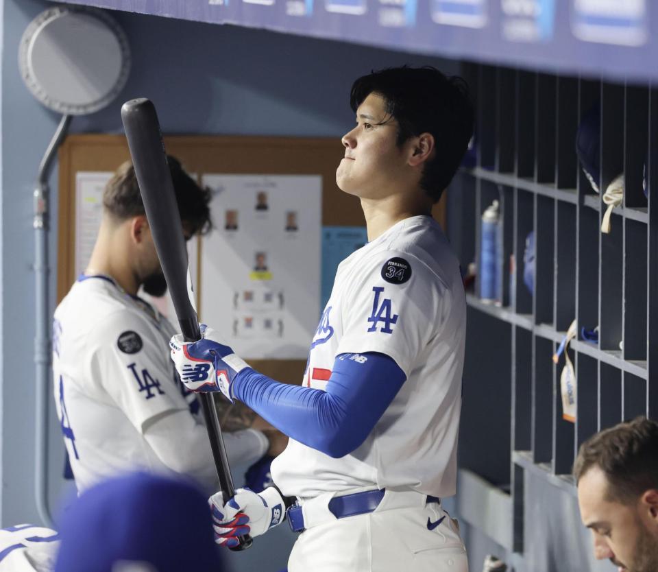 　ベンチでバットを手にする大谷（共同）