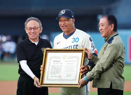 　沖縄県民栄誉賞を授与され、玉城デニー知事（左）と写真に納まるドジャースのロバーツ監督（中央）＝共同