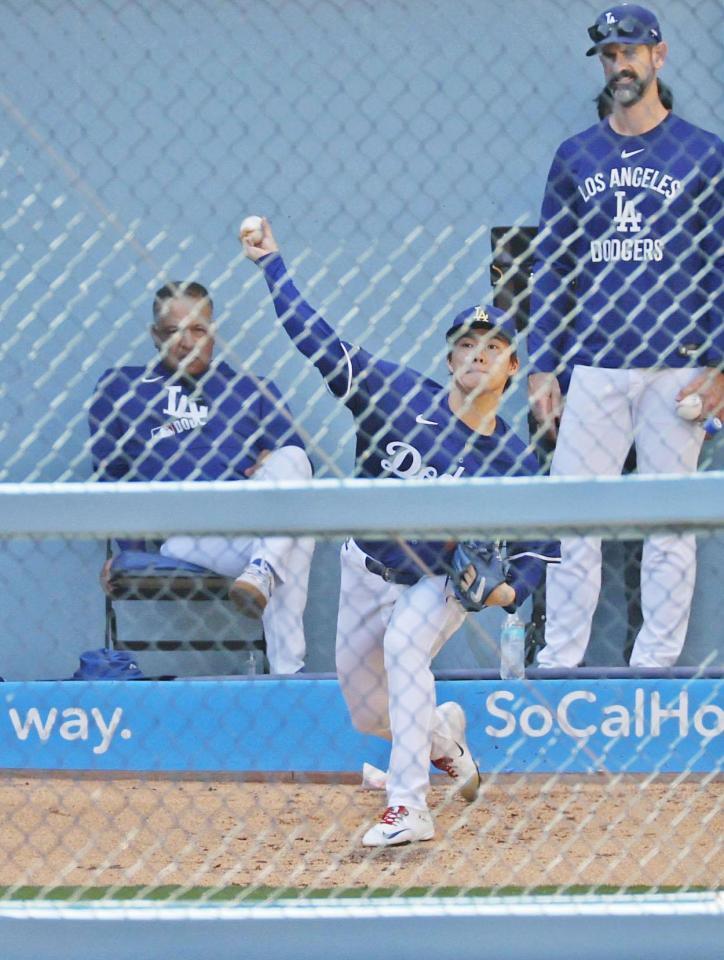 　ロバーツ監督（左）らが見守る中、投球練習するドジャース・山本（共同）