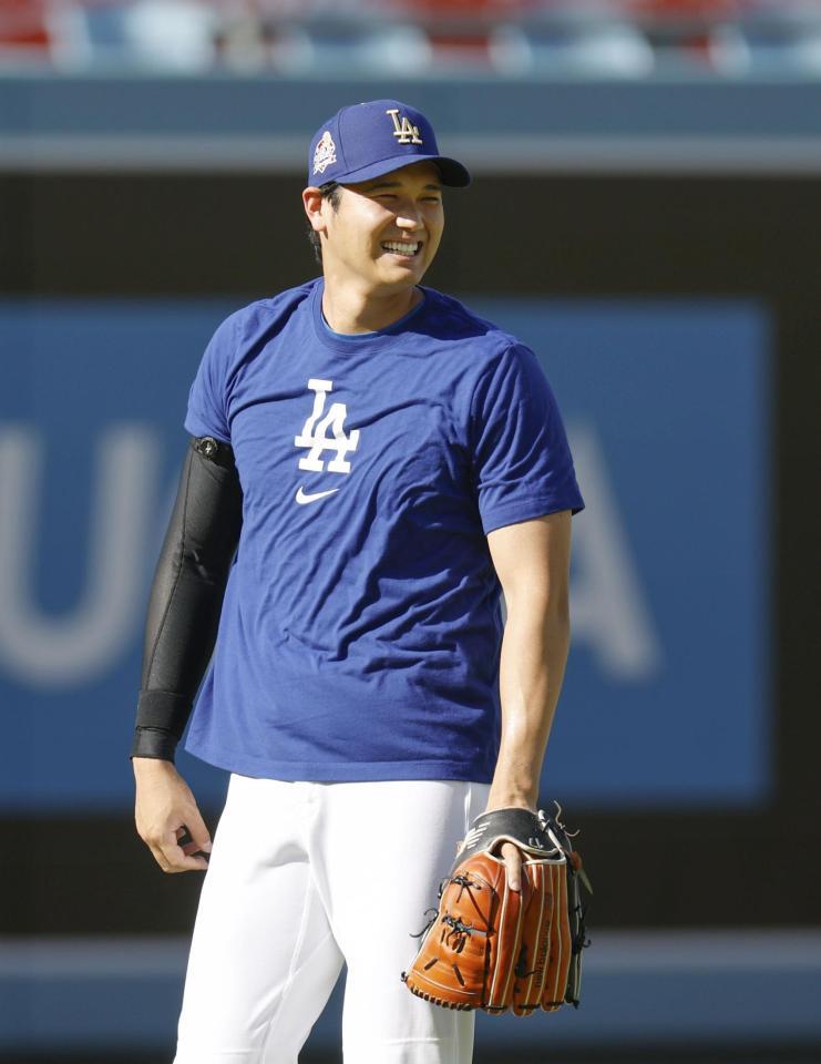 　キャッチボール中に笑顔を見せる大谷（共同）