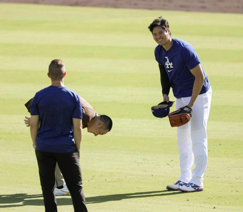 　松井（左奥）とあいさつを交わし、笑顔を見せる大谷（共同）