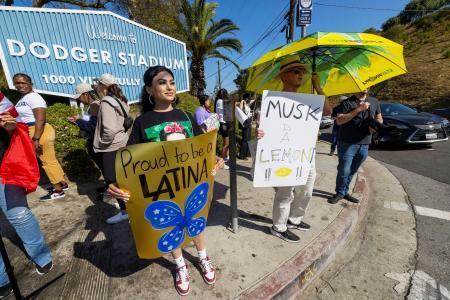 　ドジャースタジアムの外で抗議活動する人々＝１９日、ロサンゼルス（ロイター＝共同）