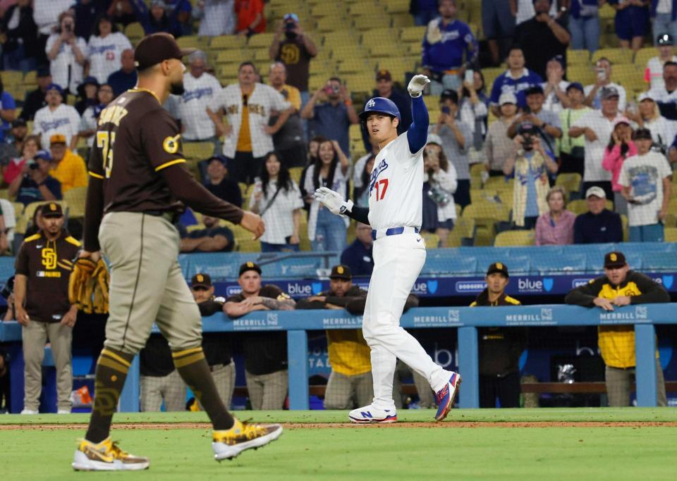 　死球を受け一塁へ向かう際、自軍ベンチを制するようなしぐさをする大谷。左は投手スアレス（共同）